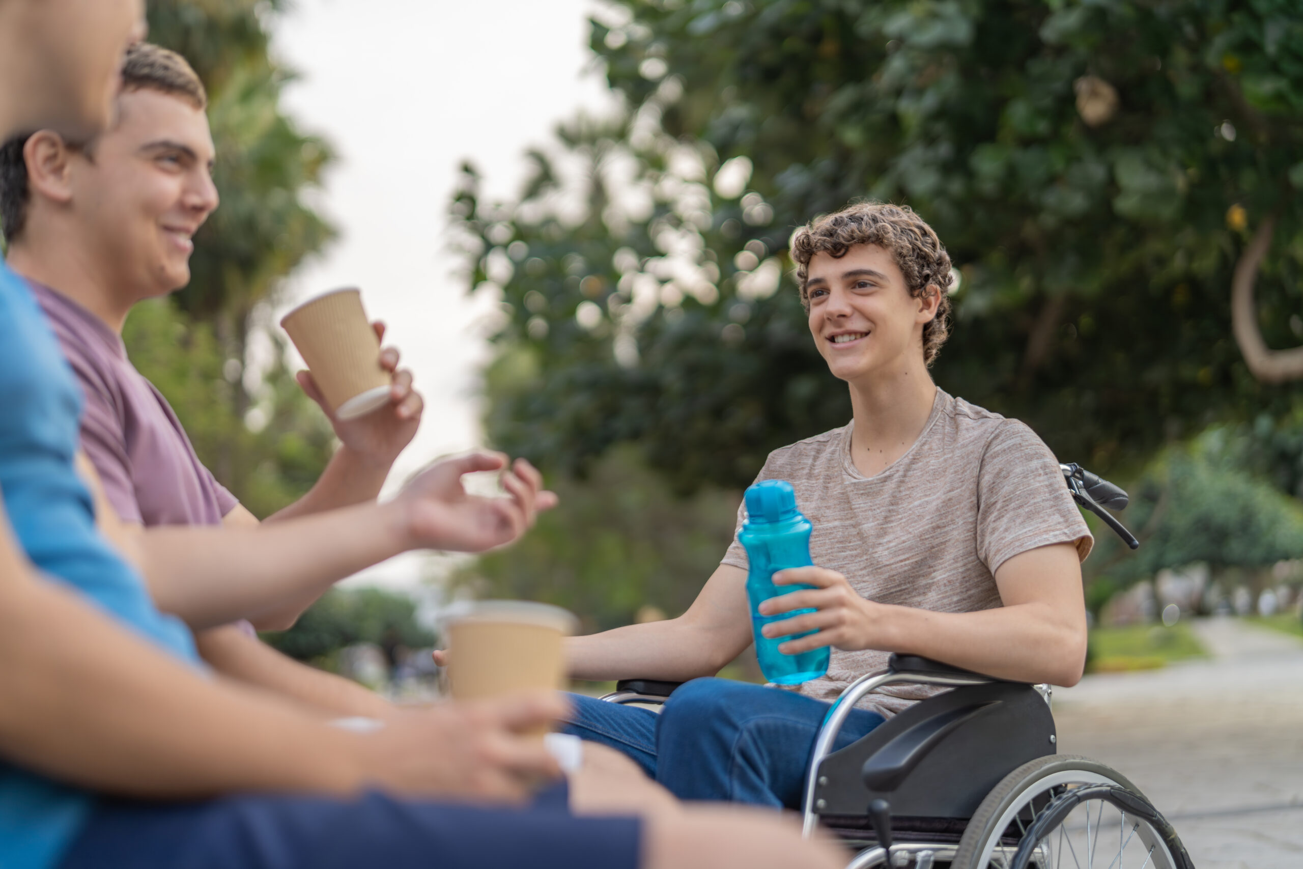 Disabled man and friends drinking coffee in a park