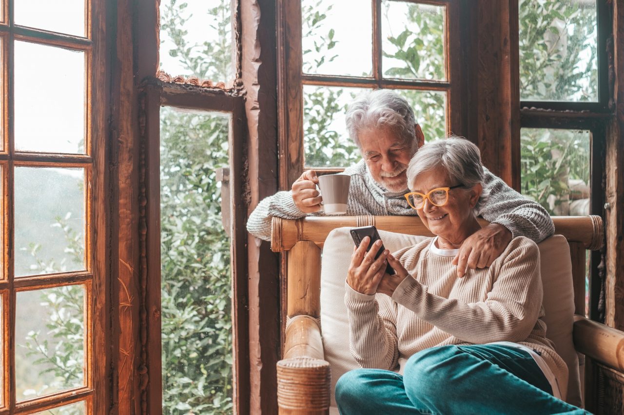 couple-of-two-old-and-mature-people-at-home-using-phone-together-in-sofa-senior-use-smartphone.jpg